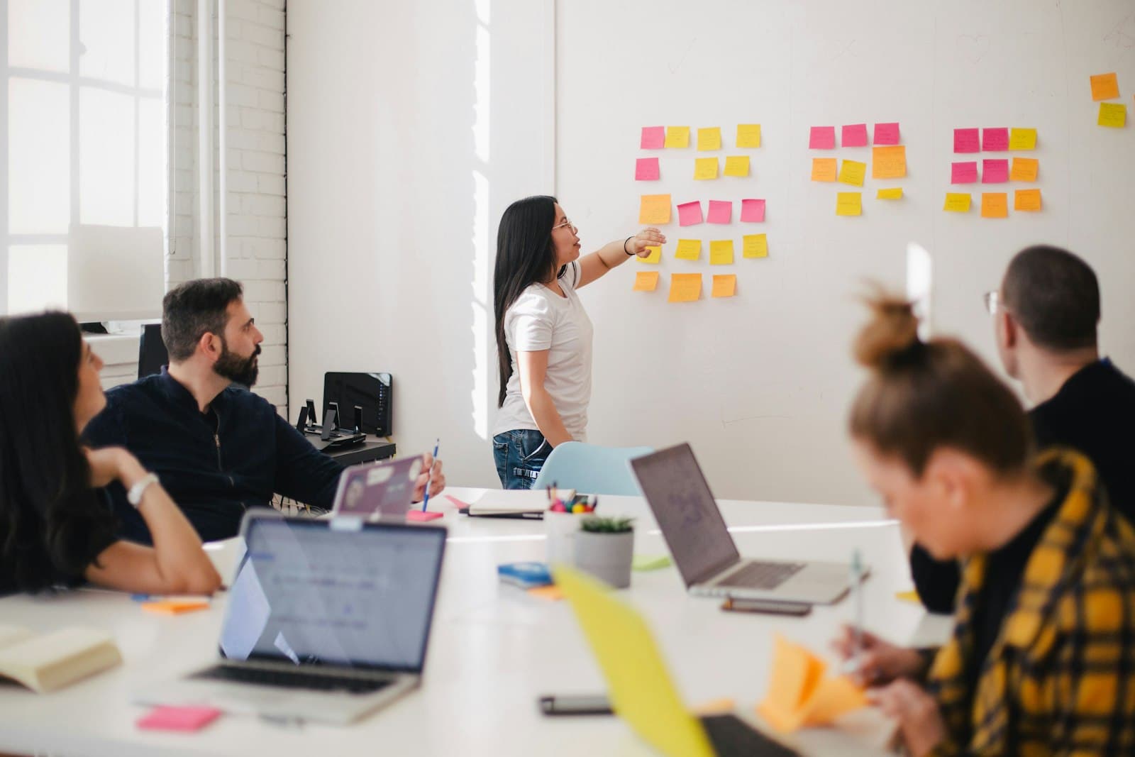 Echipă într-un workshop de mapare a proceselor, cu notițe pe perete